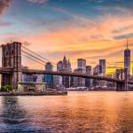 New York City Skyline On The East River With Brooklyn Bridge At Sunset.